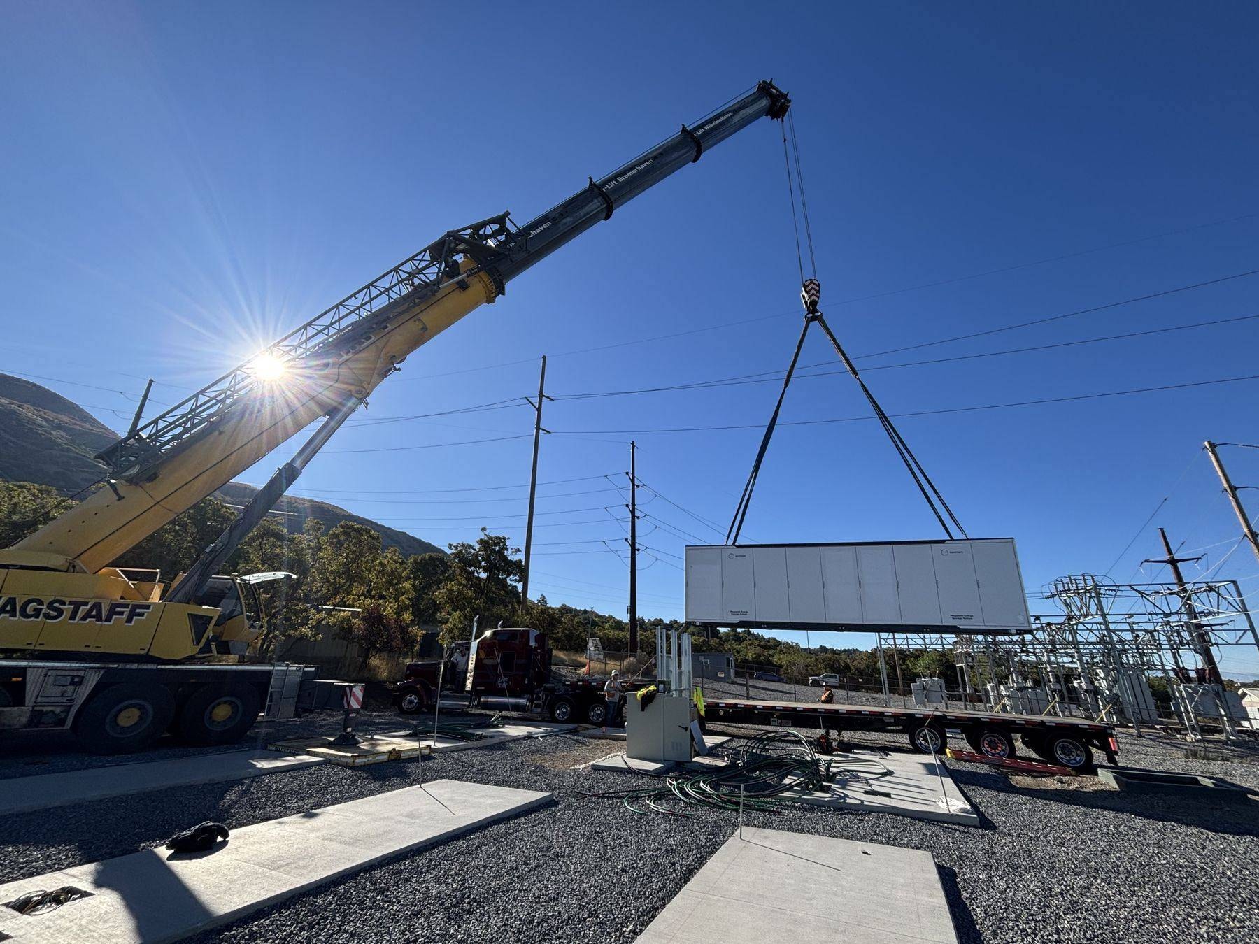 Crane setting a battery enclosure at the Weber State site